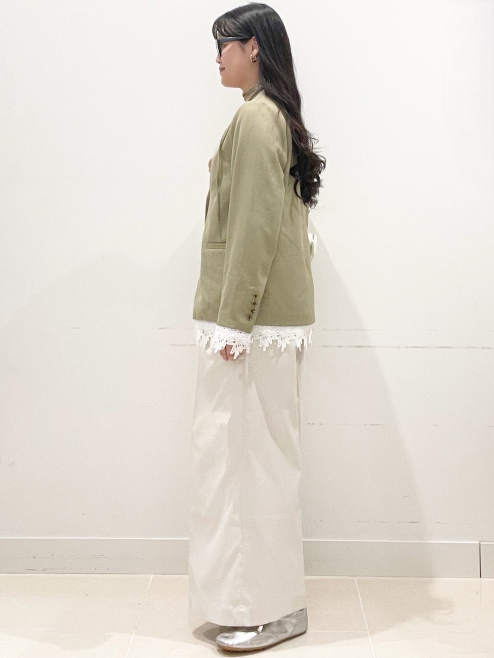 ホワイト系のチノパンツ、ベージュ系のノーカラージャケット、ホワイト系のショルダーバッグを着用したレディースの春コーディネートの6枚目の写真