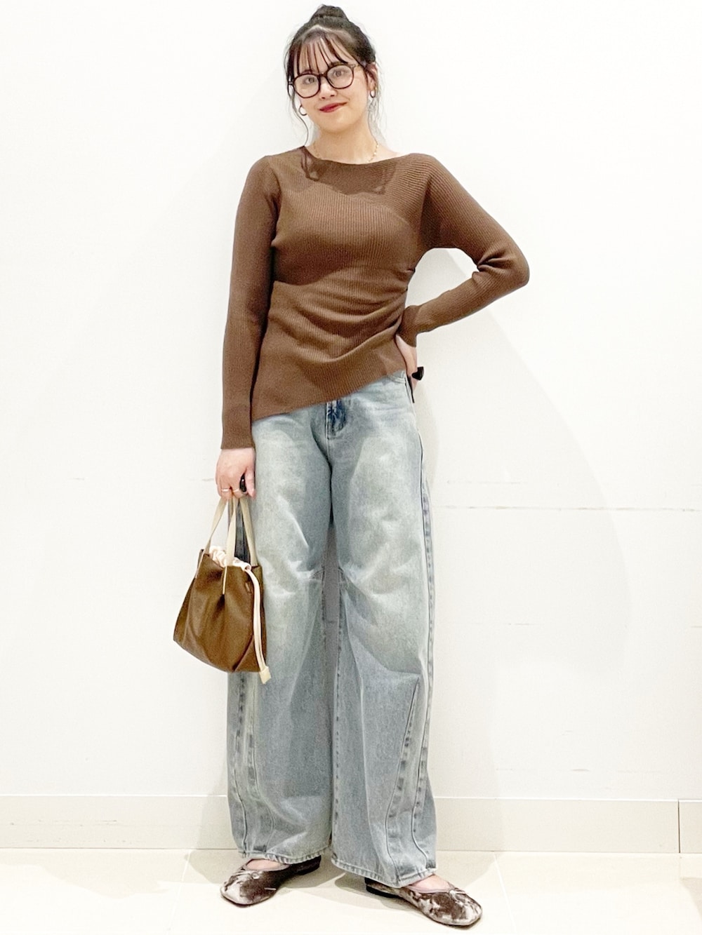 グレー系のバレエシューズ、ブルー系のデニムパンツ、ブラウン系のニット/セーターを着用したレディースの秋コーディネートの2枚目の写真