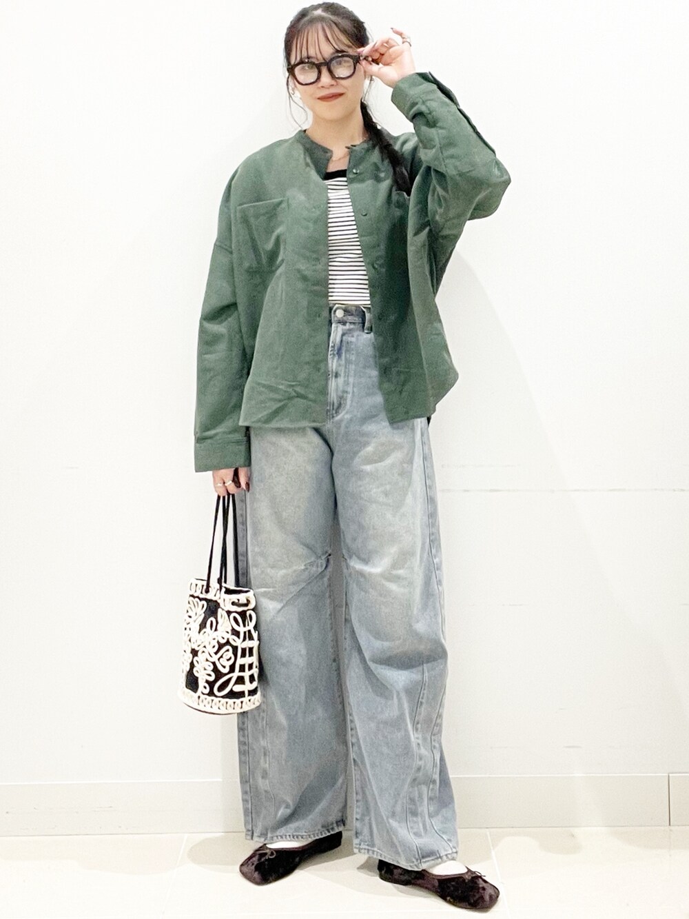 ブラウン系のバレエシューズ、ブルー系のデニムパンツ、ホワイト系のTシャツ/カットソーを着用したレディースの秋コーディネートの2枚目の写真