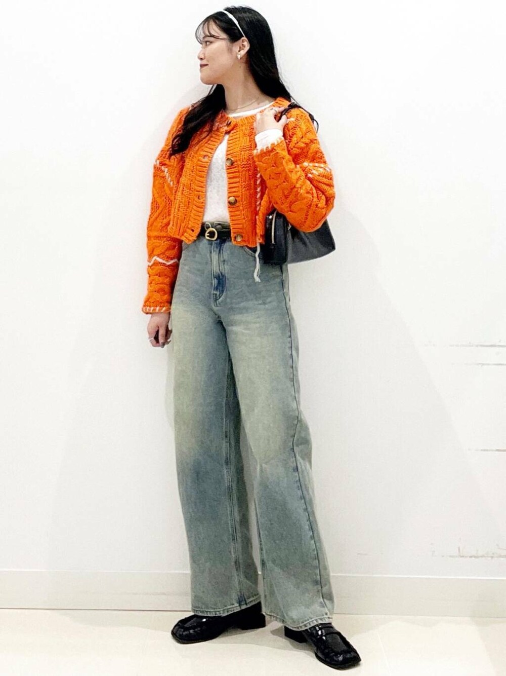 ブラック系のローファー、オレンジ系のカーディガン/ボレロ、ホワイト系のTシャツ/カットソーを着用したレディースの秋コーディネートの3枚目の写真