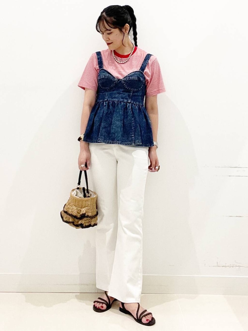 ホワイト系のデニムパンツ、ブラック系のサンダル、ブルー系のベストを着用したレディースの夏コーディネートの4枚目の写真