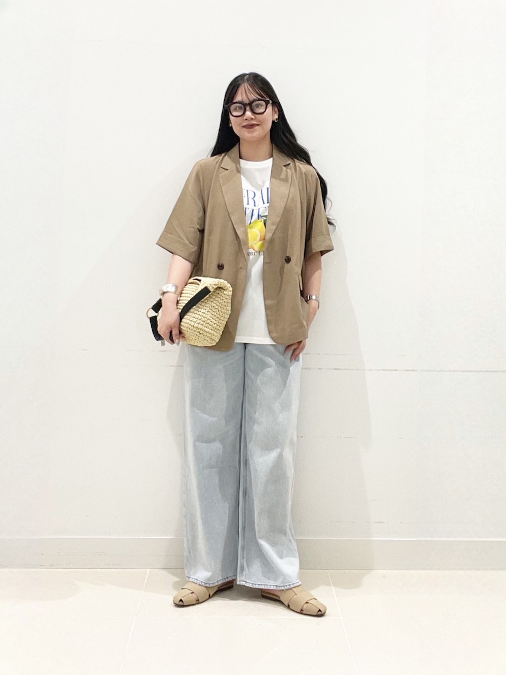 ベージュ系のテーラードジャケット、ホワイト系のTシャツ/カットソー、ブルー系のデニムパンツを着用したレディースの夏コーディネートの2枚目の写真