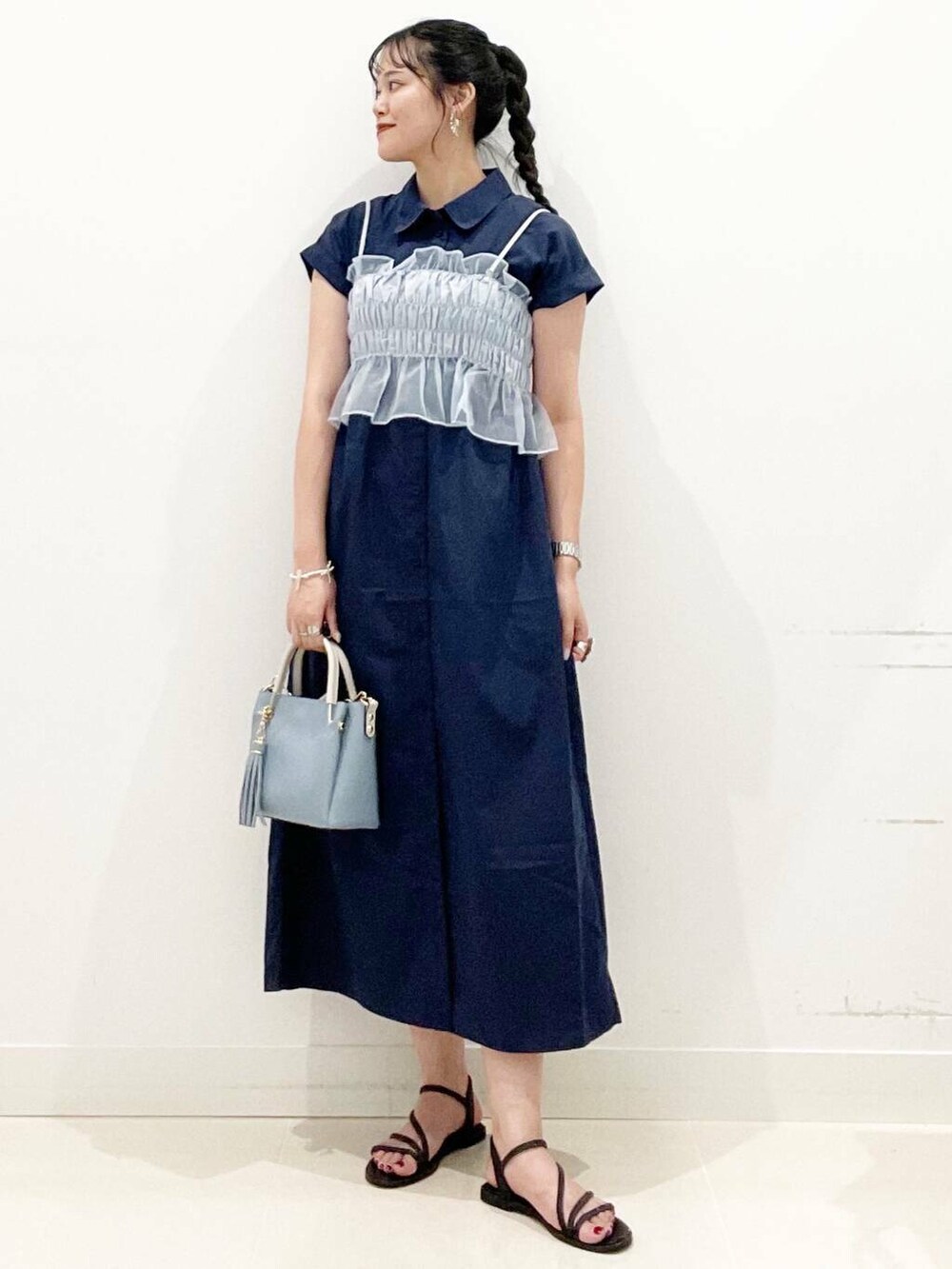 ブルー系のトートバッグ、ブラック系のサンダル、ブルー系のワンピースを着用したレディースの夏コーディネートの4枚目の写真