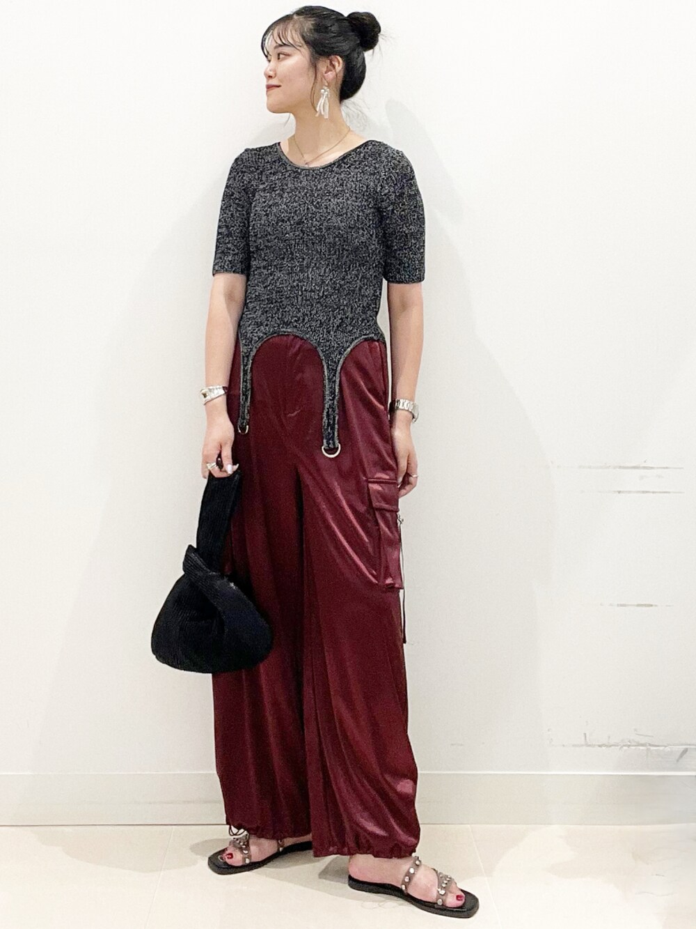 ブラック系のサンダル、ブラック系のハンドバッグ、レッド系のカーゴパンツを着用したレディースの夏コーディネートの4枚目の写真