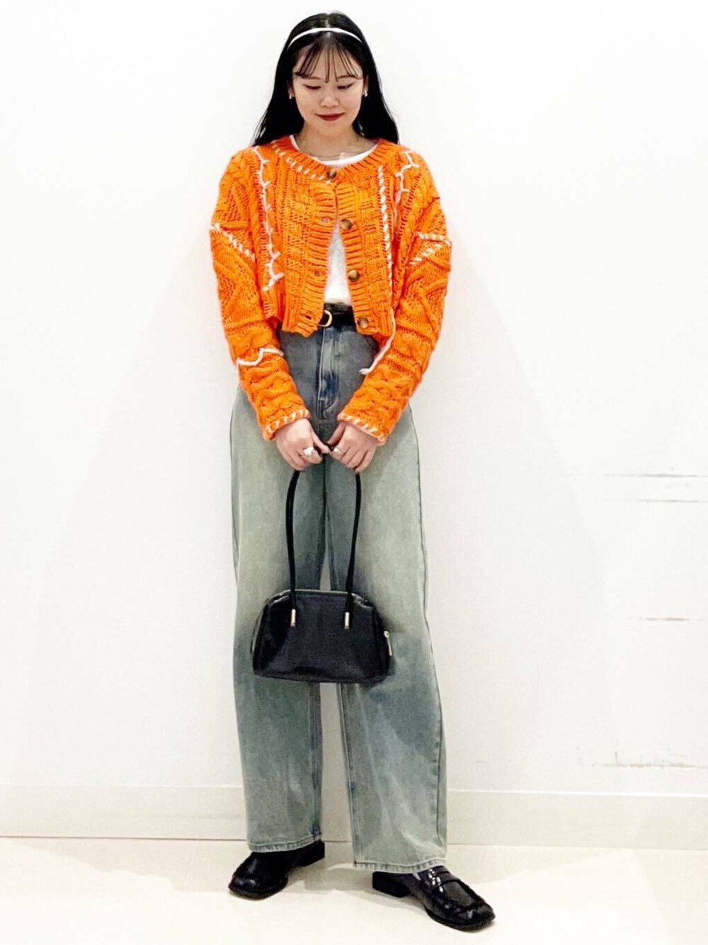 ブラック系のローファー、オレンジ系のカーディガン/ボレロ、ホワイト系のTシャツ/カットソーを着用したレディースの秋コーディネートの4枚目の写真