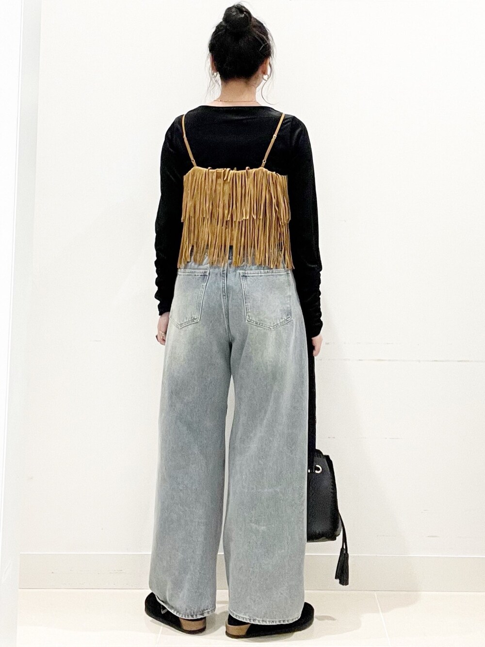 ブラック系のサンダル、ブラック系のショルダーバッグ、ブルー系のデニムパンツを着用したレディースの秋コーディネートの6枚目の写真