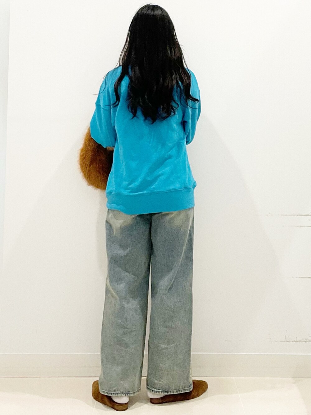 ブラウン系のハンドバッグ、イエロー系のその他シューズ、ブルー系のデニムパンツを着用したレディースの秋コーディネートの6枚目の写真