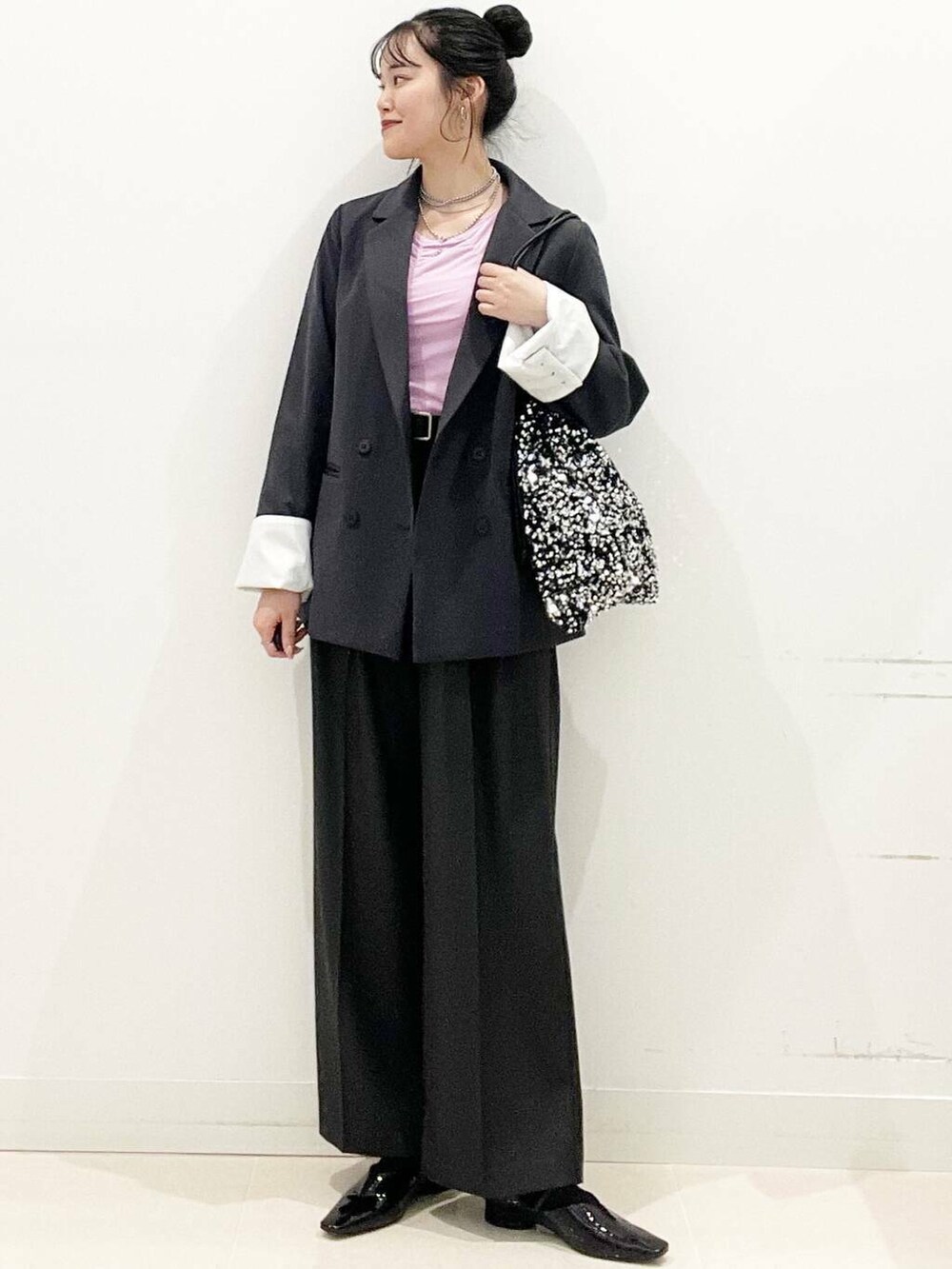 シルバー系のトートバッグ、グレー系のテーラードジャケット、グレー系のその他パンツを着用したレディースの冬コーディネートの2枚目の写真