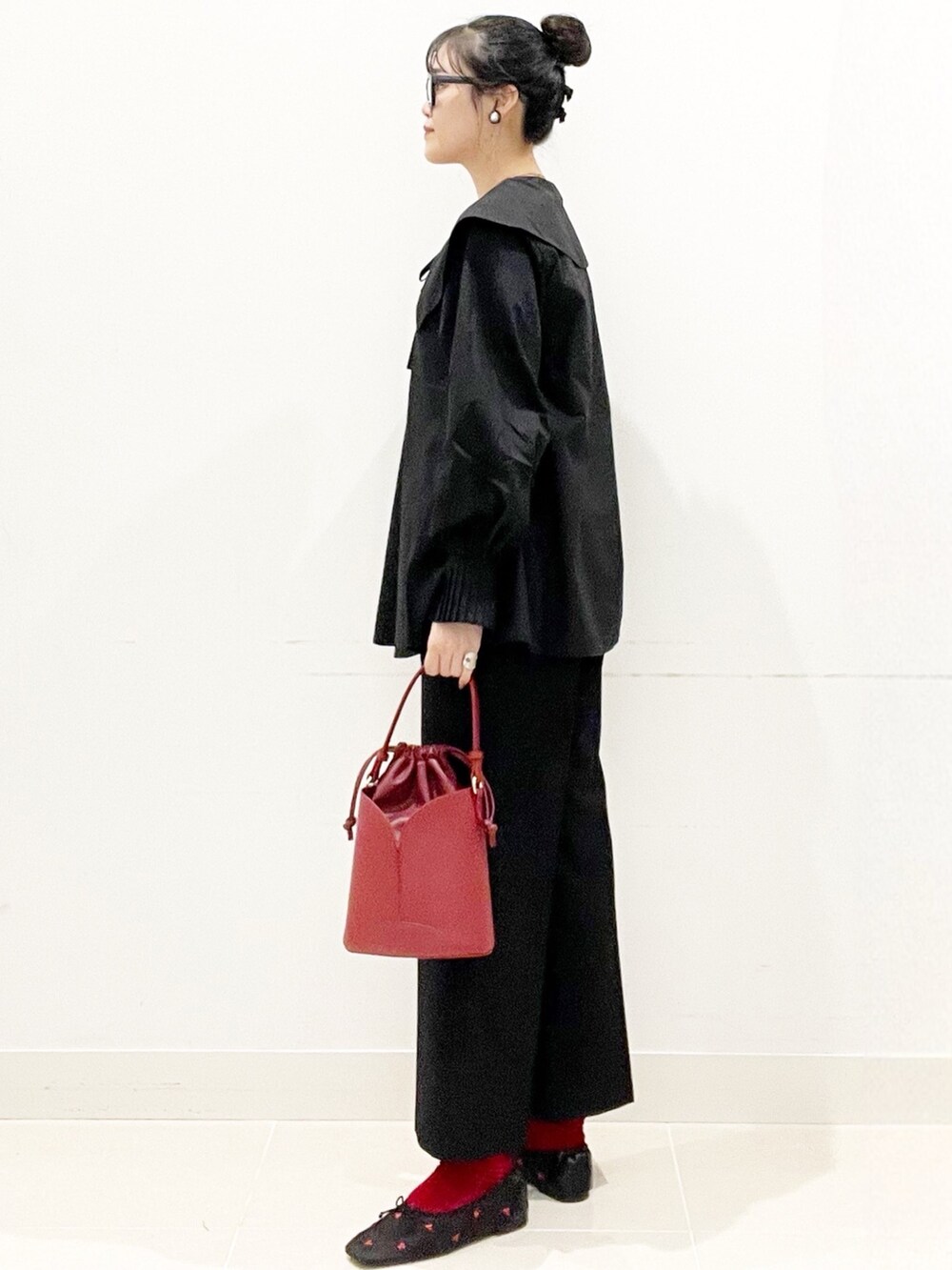 ブラック系のバレエシューズ、ブラック系のその他パンツ、レッド系のハンドバッグを着用したレディースの秋コーディネートの5枚目の写真