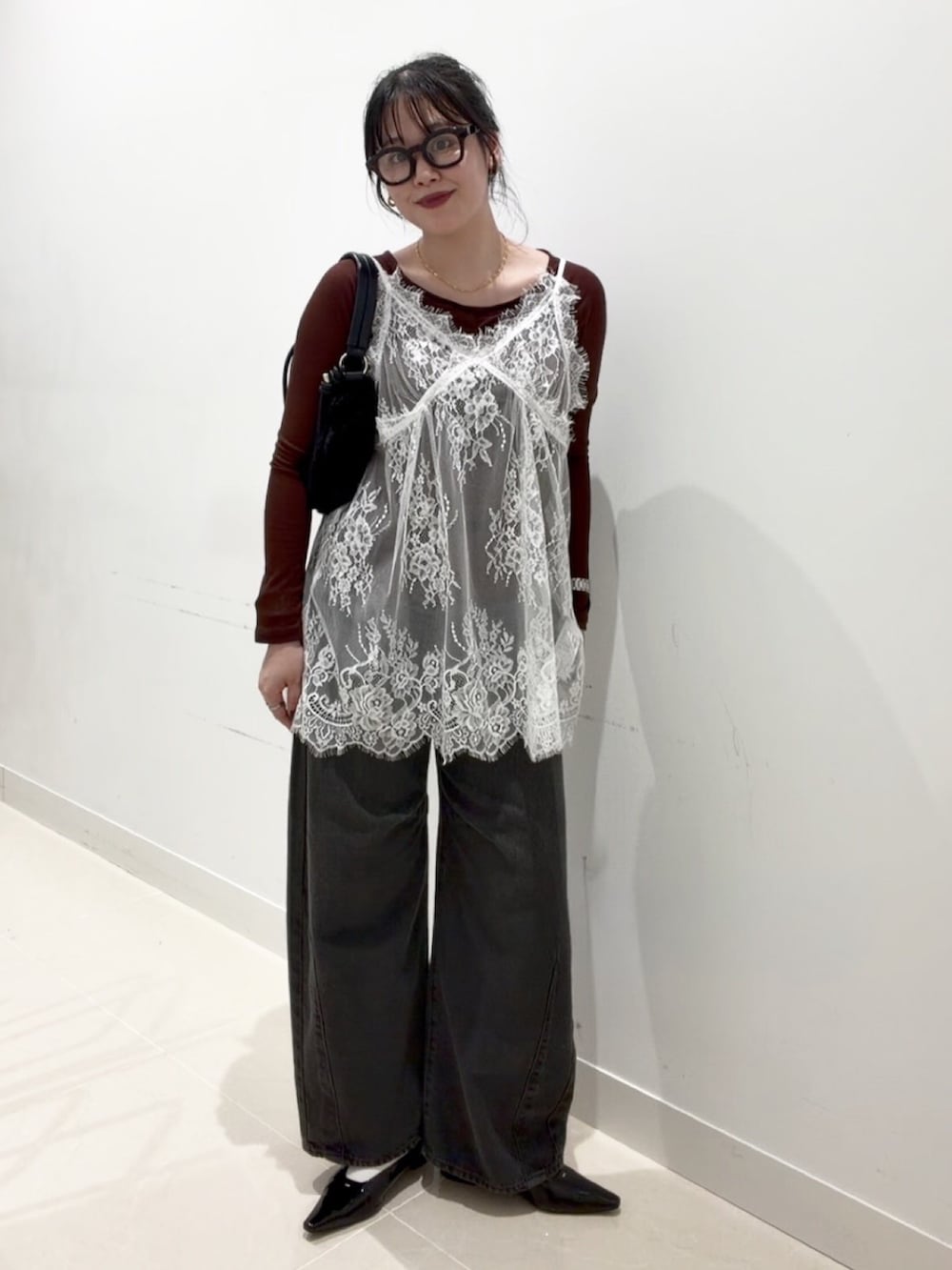 ブラウン系のTシャツ/カットソー、ホワイト系のキャミソール、グレー系のデニムパンツを着用したレディースの秋コーディネートの3枚目の写真