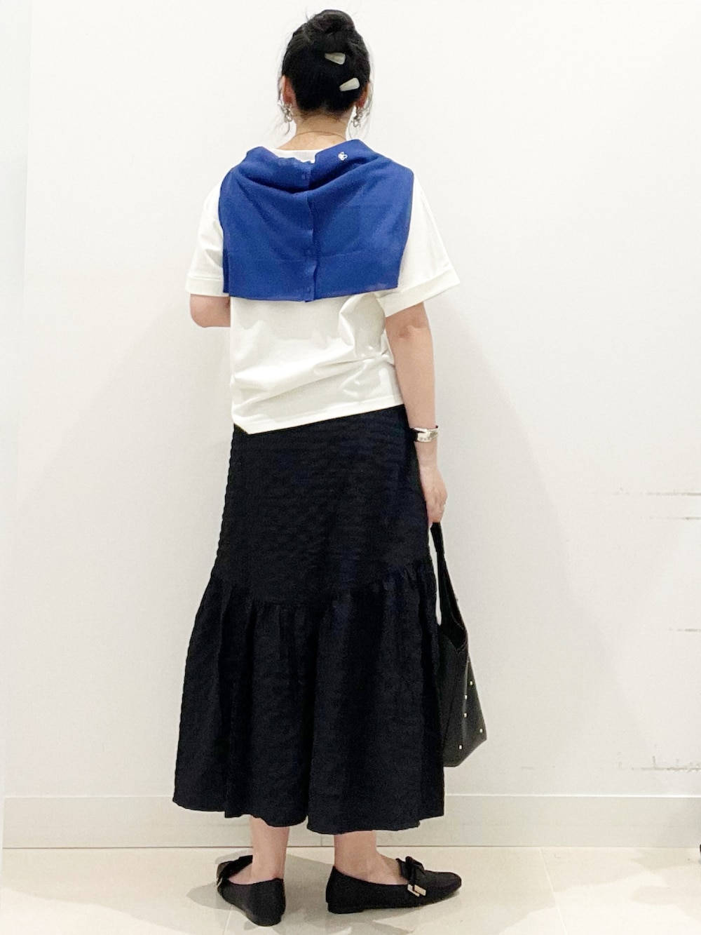 ブラック系のドレスシューズ、ブラック系のスカート、ホワイト系のTシャツ/カットソーを着用したレディースの夏コーディネートの5枚目の写真