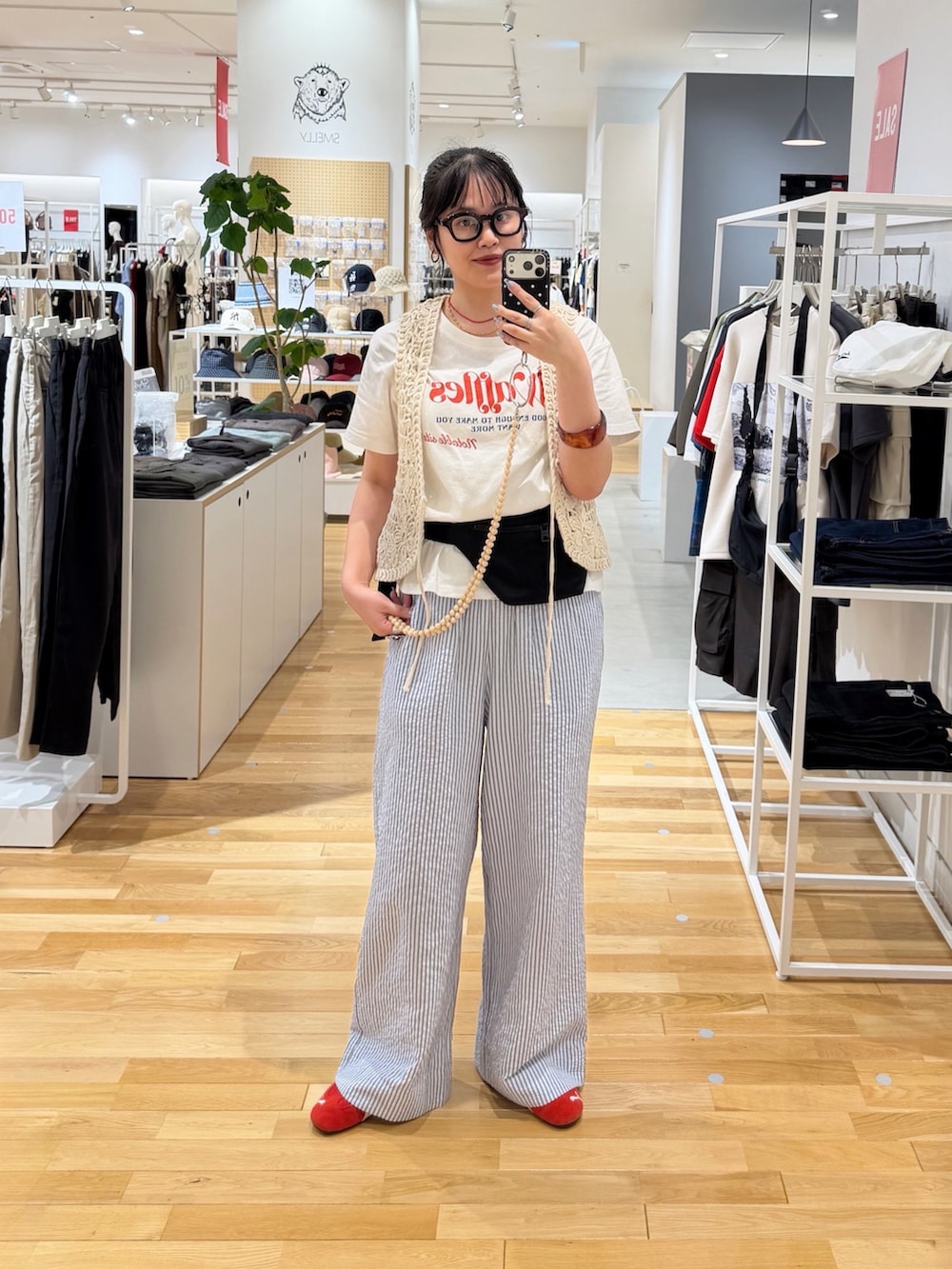 レッド系のスニーカー、ブルー系のその他パンツ、ベージュ系のスマホグッズを着用したレディースの夏コーディネートの2枚目の写真