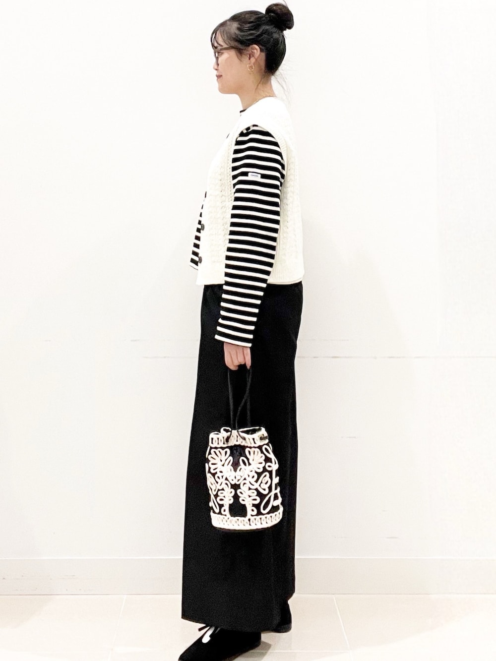 ブラック系のその他シューズ、ブラック系のその他パンツ、ブラック系のハンドバッグを着用したレディースの秋コーディネートの7枚目の写真