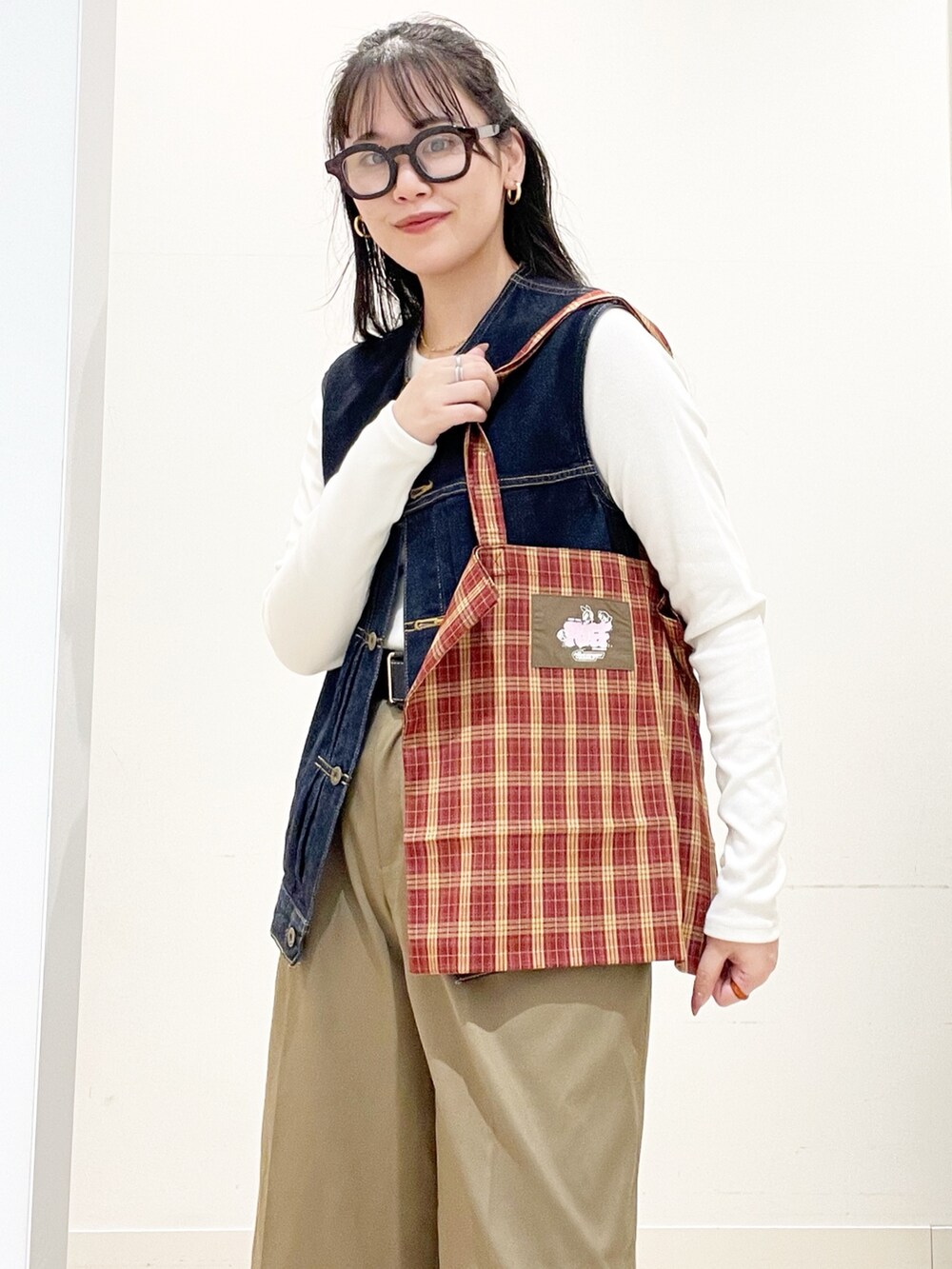 ベージュ系のその他パンツ、レッド系のトートバッグ、ホワイト系のTシャツ/カットソーを着用したレディースの秋コーディネートの5枚目の写真