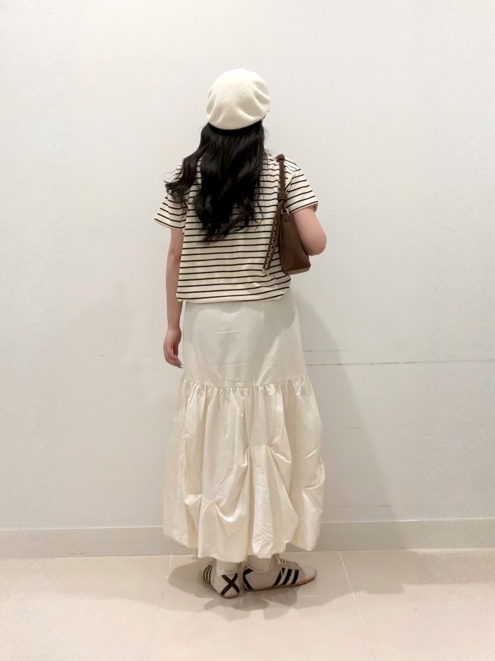 ホワイト系のTシャツ/カットソー、ホワイト系のスカート、ホワイト系のスニーカーを着用したレディースの夏コーディネートの4枚目の写真