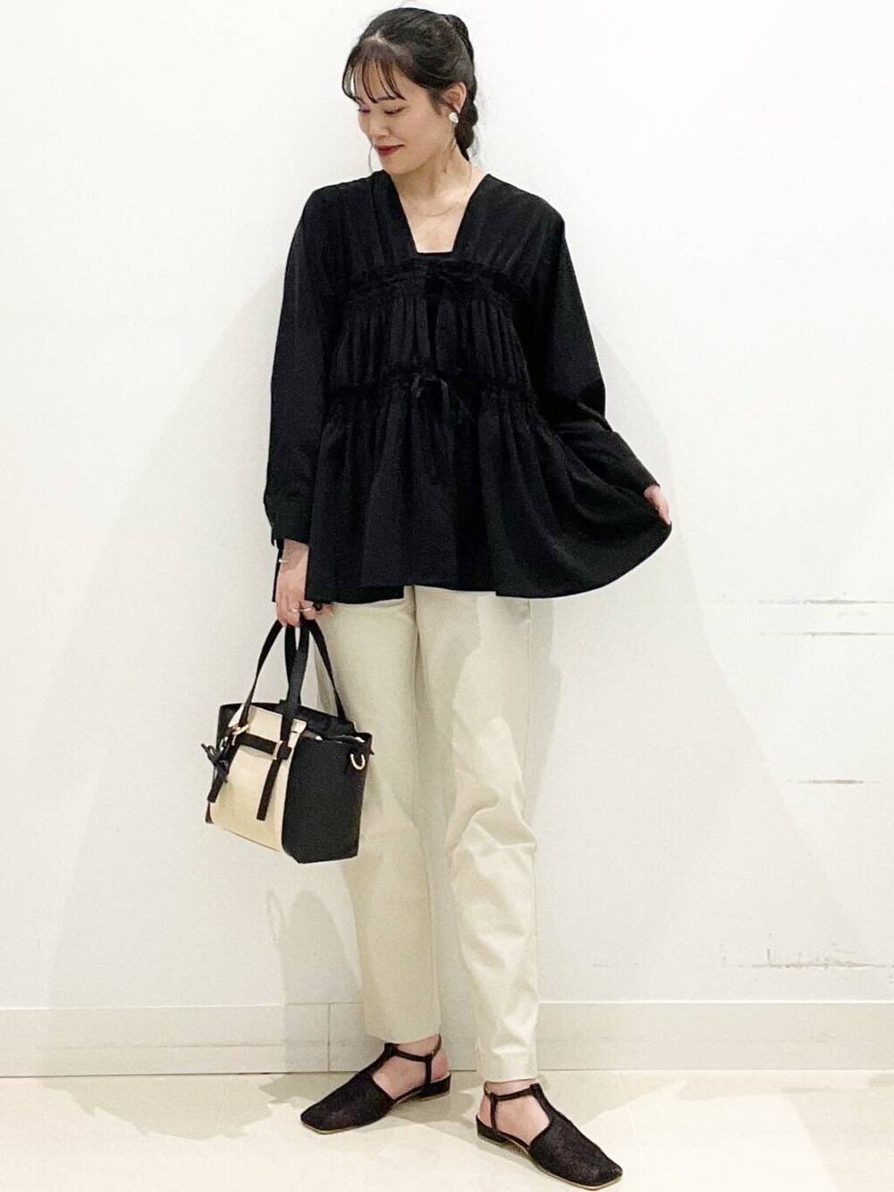 ベージュ系のその他パンツ、ブラック系のトートバッグ、ブラック系のキャミソールを着用したレディースの春コーディネートの2枚目の写真