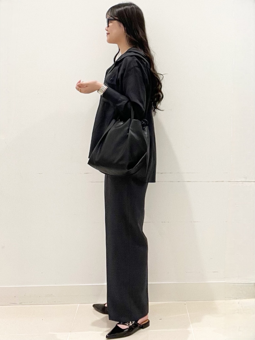 ブラック系のパンプス、グレー系のその他パンツ、ブラック系のショルダーバッグを着用したレディースの春コーディネートの5枚目の写真