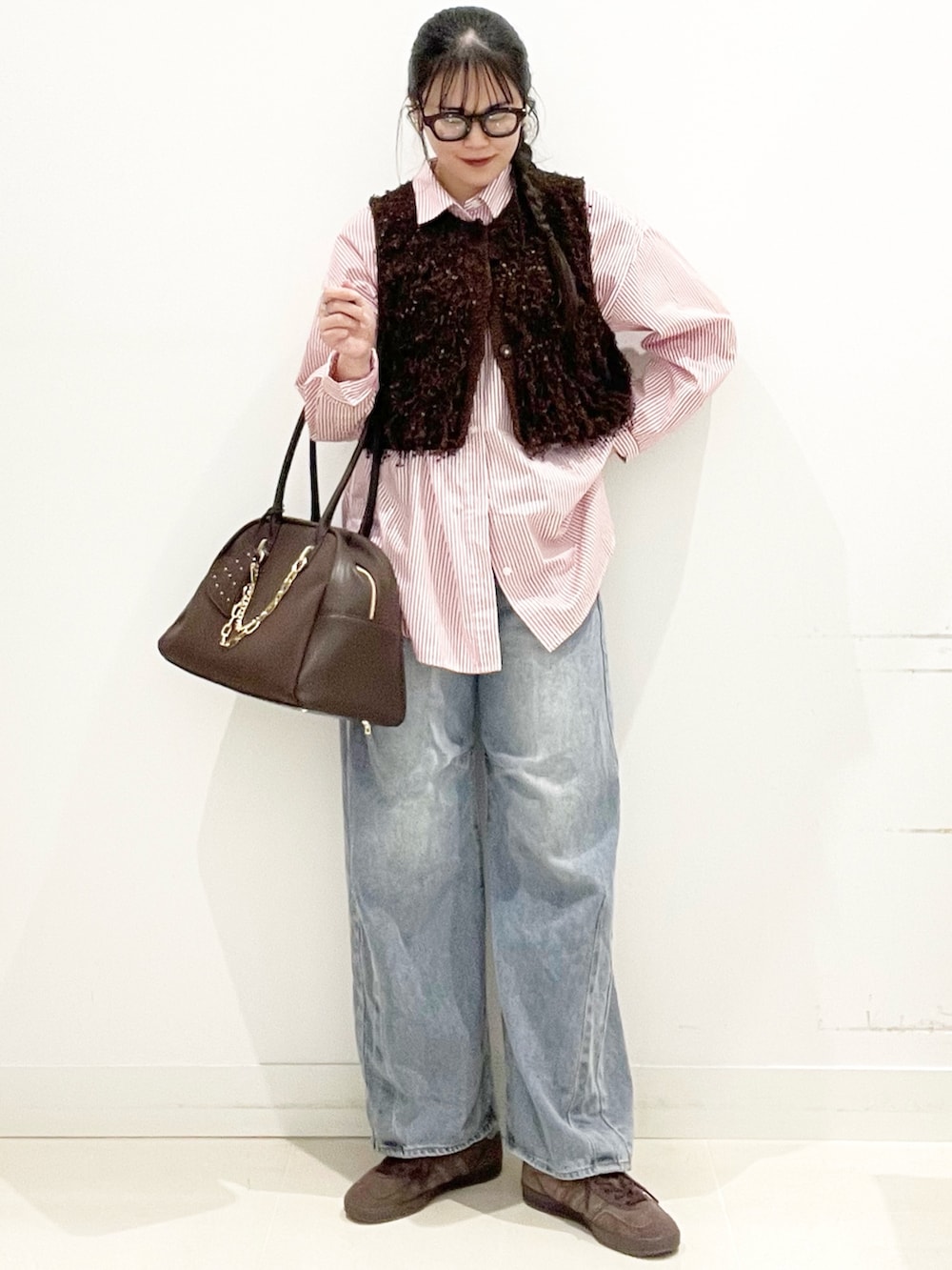 ブラウン系のスニーカー、ブルー系のデニムパンツ、ブラウン系のボストンバッグを着用したレディースの冬コーディネートの4枚目の写真