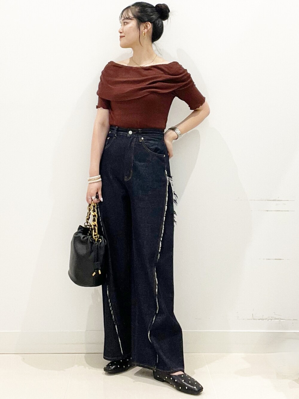 ブルー系のデニムパンツ、ブラック系のショルダーバッグ、ブラック系のパンプスを着用したレディースの夏コーディネートの6枚目の写真