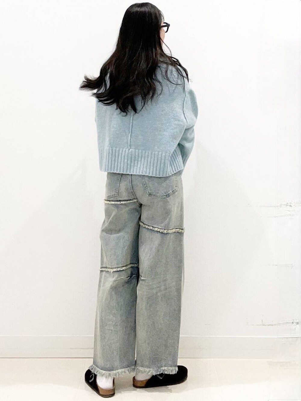 ブラック系のボストンバッグ、ブラック系のサンダル、ブルー系のニット/セーターを着用したレディースの冬コーディネートの5枚目の写真