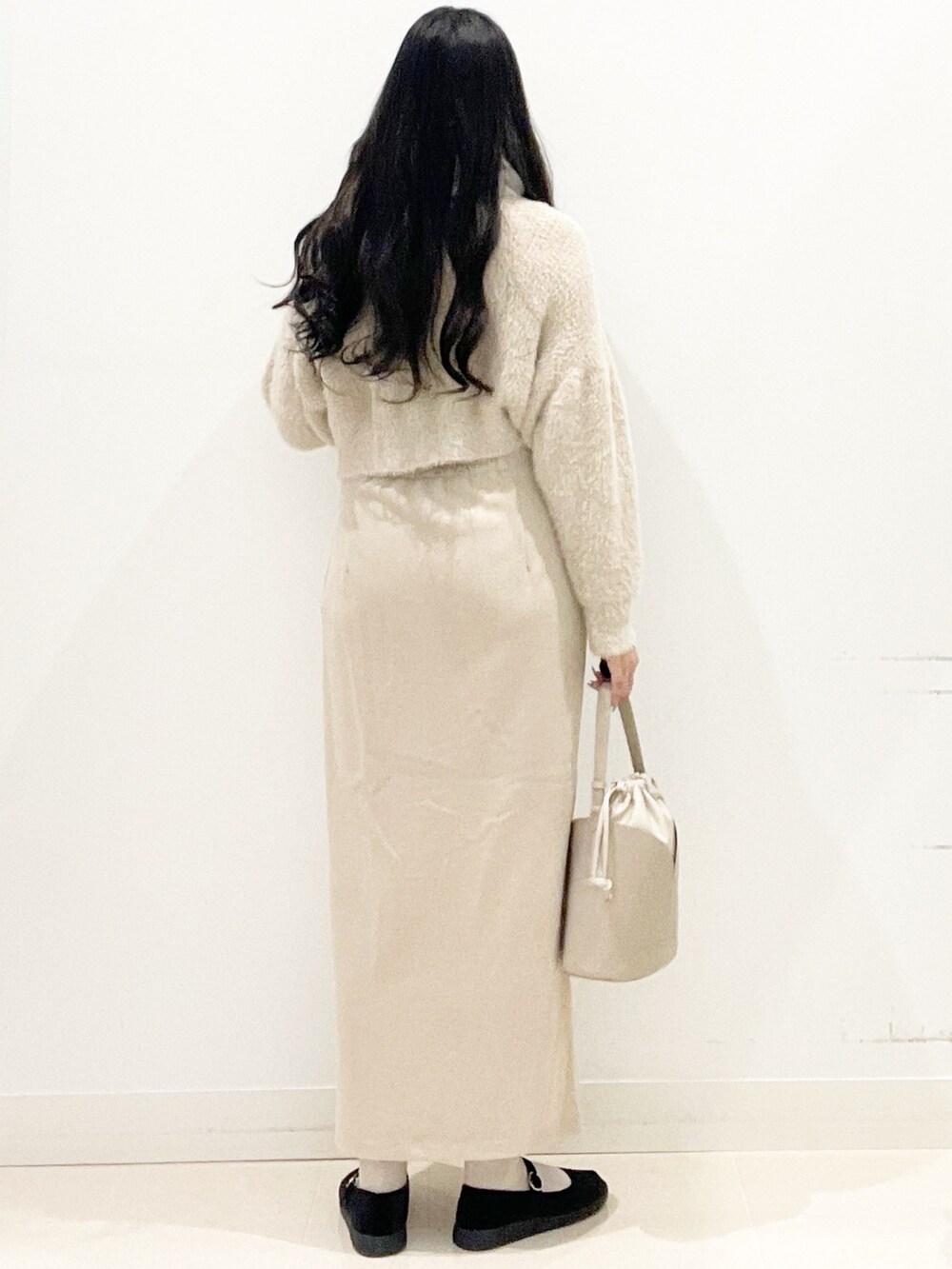 ブラック系のその他シューズ、ベージュ系のスカート、ベージュ系のハンドバッグを着用したレディースの秋コーディネートの8枚目の写真