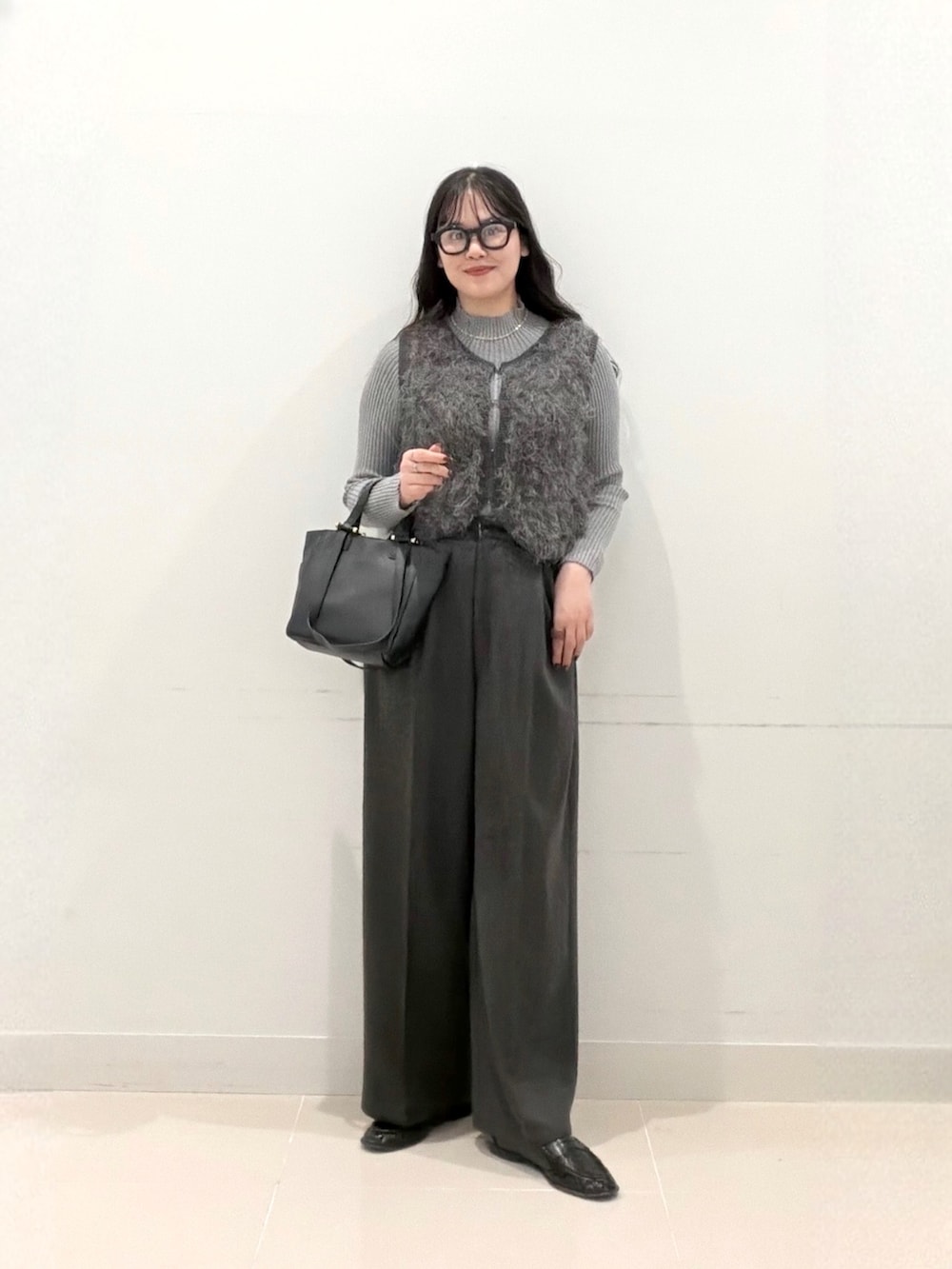グレー系のその他パンツ、ブラック系のトートバッグ、グレー系のニット/セーターを着用したレディースの秋コーディネートの2枚目の写真