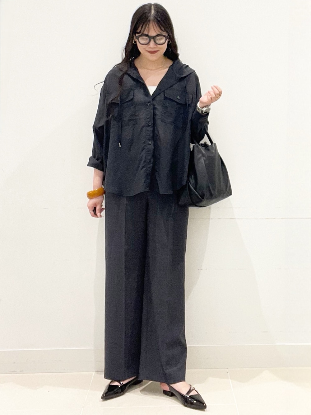 ブラック系のパンプス、グレー系のその他パンツ、ブラック系のショルダーバッグを着用したレディースの春コーディネートの4枚目の写真