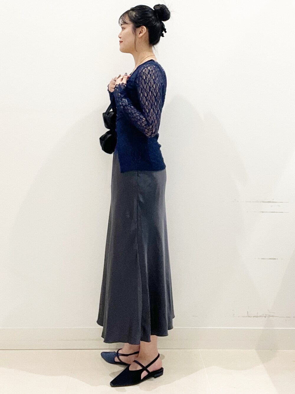 ブラック系のキャミソール、ブラック系のハンドバッグ、ブルー系のパンプスを着用したレディースの秋コーディネートの6枚目の写真