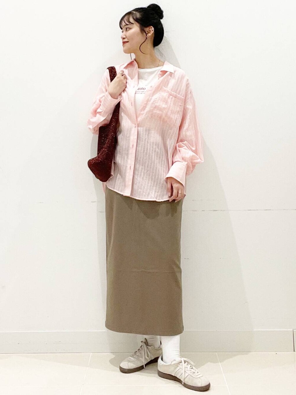 ホワイト系のスニーカー、ブラウン系のスカート、ホワイト系のキャミソールを着用したレディースの春コーディネートの3枚目の写真