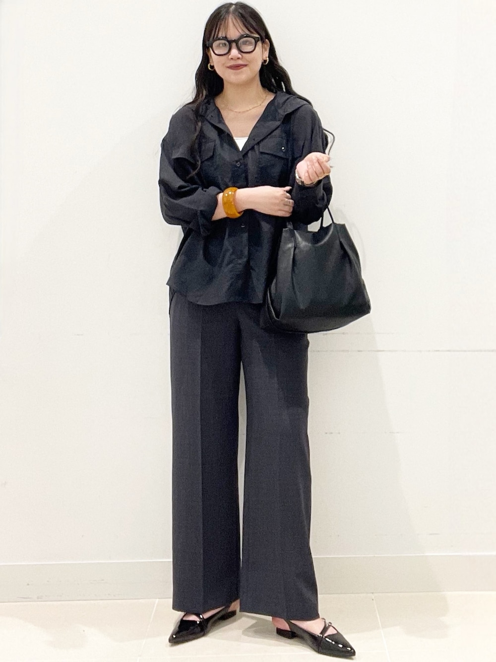 ブラック系のパンプス、グレー系のその他パンツ、ブラック系のショルダーバッグを着用したレディースの春コーディネートの2枚目の写真