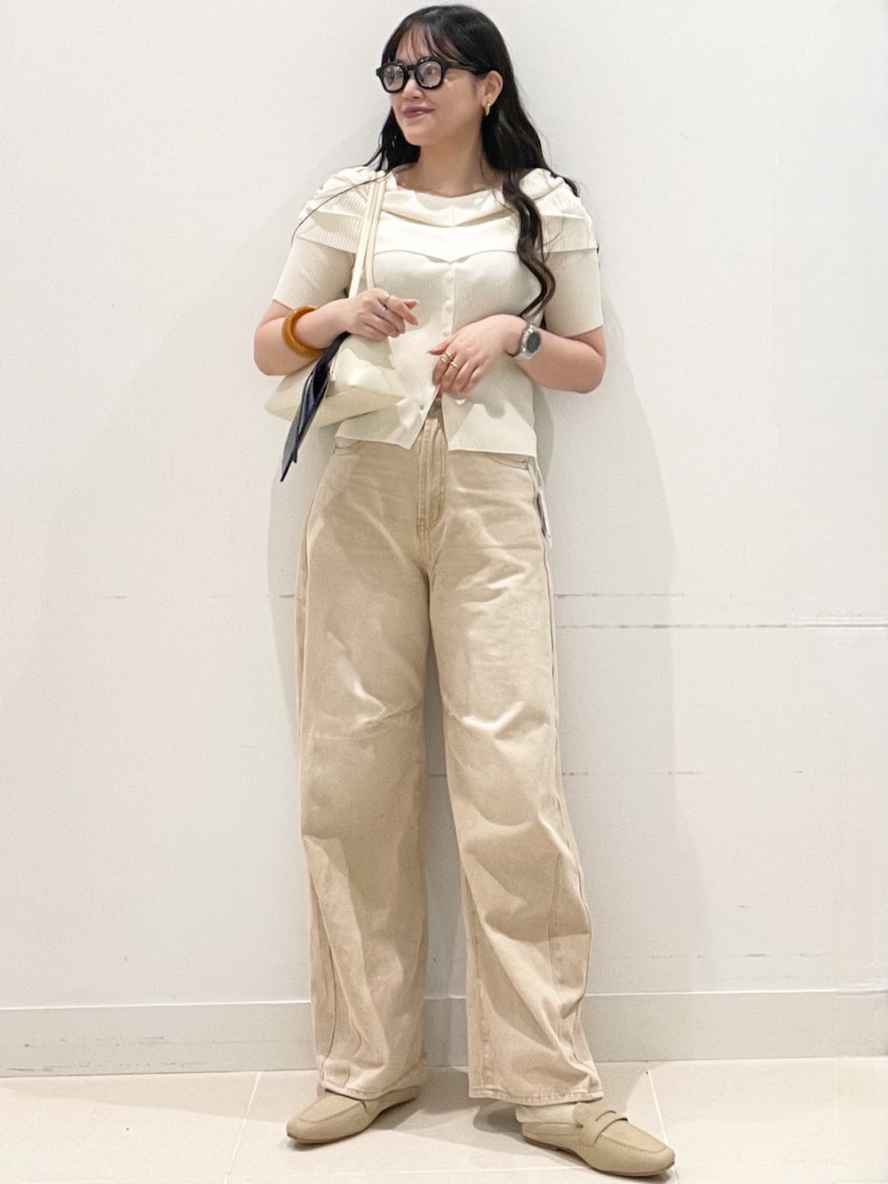 ベージュ系のローファー、ベージュ系のデニムパンツ、ホワイト系のニット/セーターを着用したレディースの春コーディネートの3枚目の写真