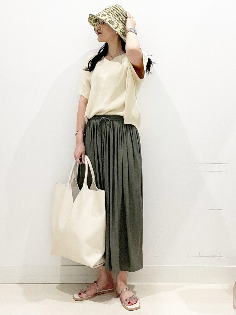 ホワイト系のトートバッグ、グリーン系のその他パンツ、ホワイト系のサンダルを着用したレディースの夏コーディネートの2枚目の写真