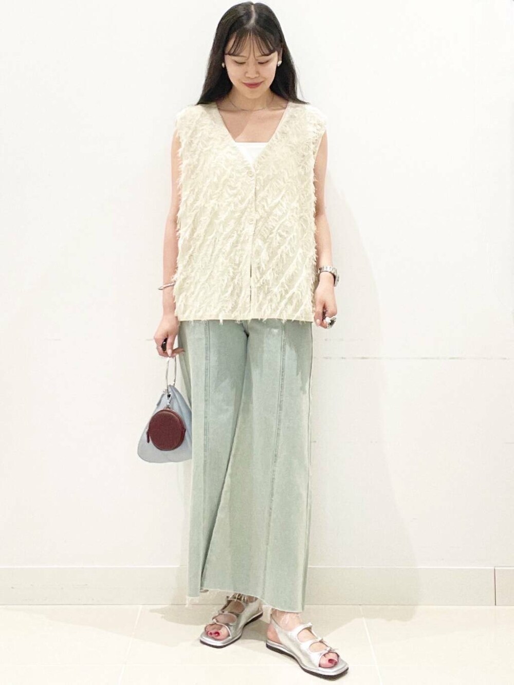 ブルー系のハンドバッグ、ホワイト系のキャミソール、シルバー系のサンダルを着用したレディースの夏コーディネートの4枚目の写真