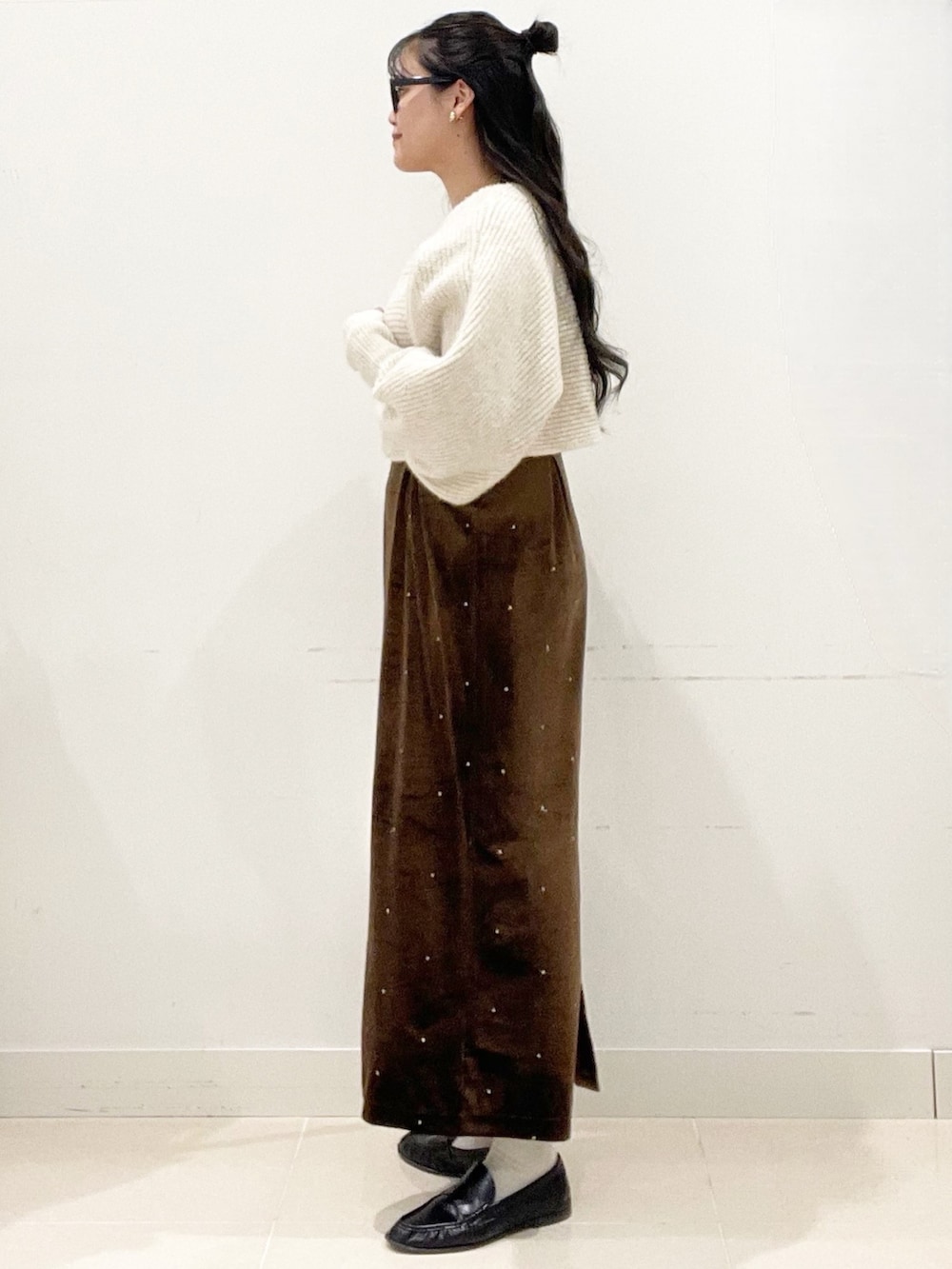 ホワイト系のショルダーバッグ、ブラウン系のワンピース、ベージュ系のニット/セーターを着用したレディースの冬コーディネートの4枚目の写真