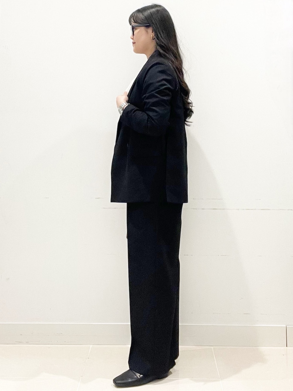 ブラック系のローファー、ブラック系のハンドバッグ、ブラック系のテーラードジャケットを着用したレディースの春コーディネートの4枚目の写真