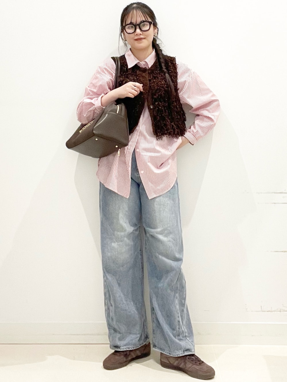 ブラウン系のスニーカー、ブルー系のデニムパンツ、ブラウン系のボストンバッグを着用したレディースの冬コーディネートの2枚目の写真