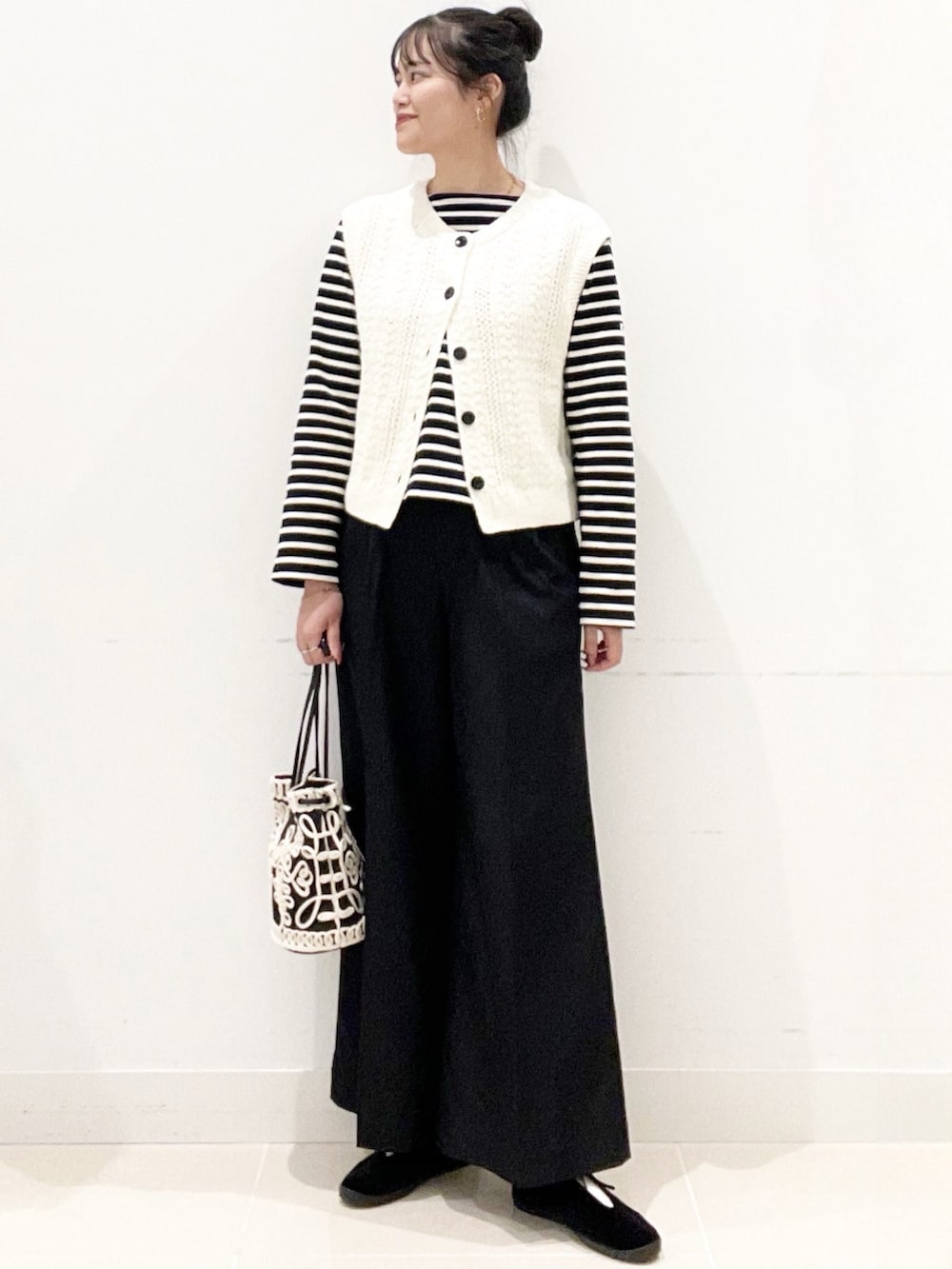 ブラック系のその他シューズ、ブラック系のその他パンツ、ブラック系のハンドバッグを着用したレディースの秋コーディネートの6枚目の写真