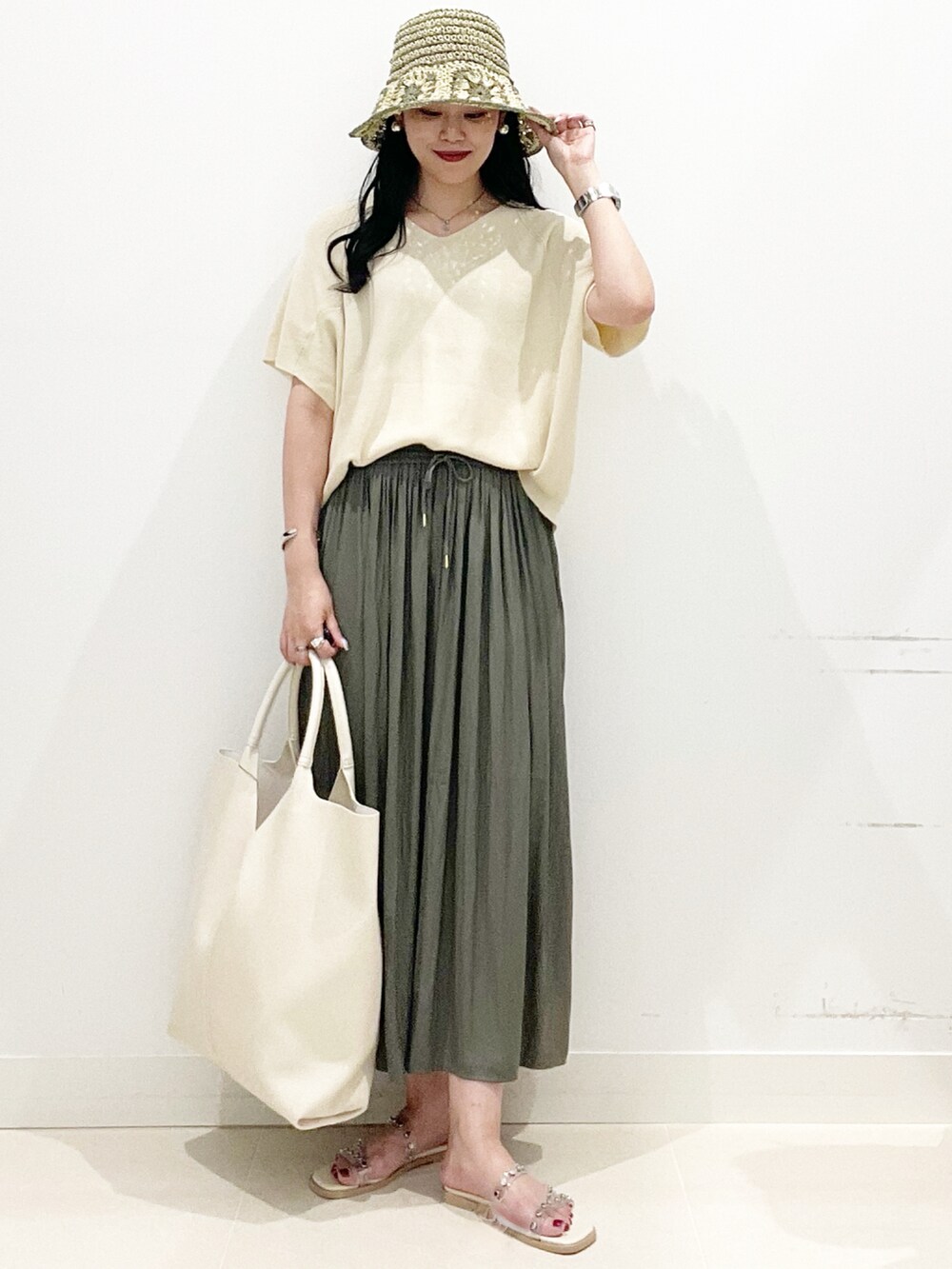 ホワイト系のトートバッグ、グリーン系のその他パンツ、ホワイト系のサンダルを着用したレディースの夏コーディネートの4枚目の写真