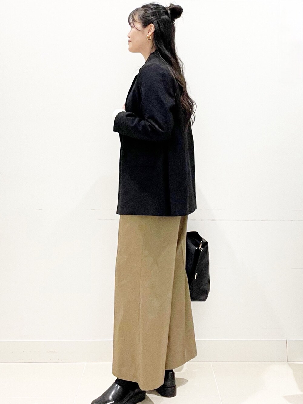 ベージュ系のその他パンツ、ブラック系のトートバッグ、ブラック系のその他アウターを着用したレディースの秋コーディネートの7枚目の写真