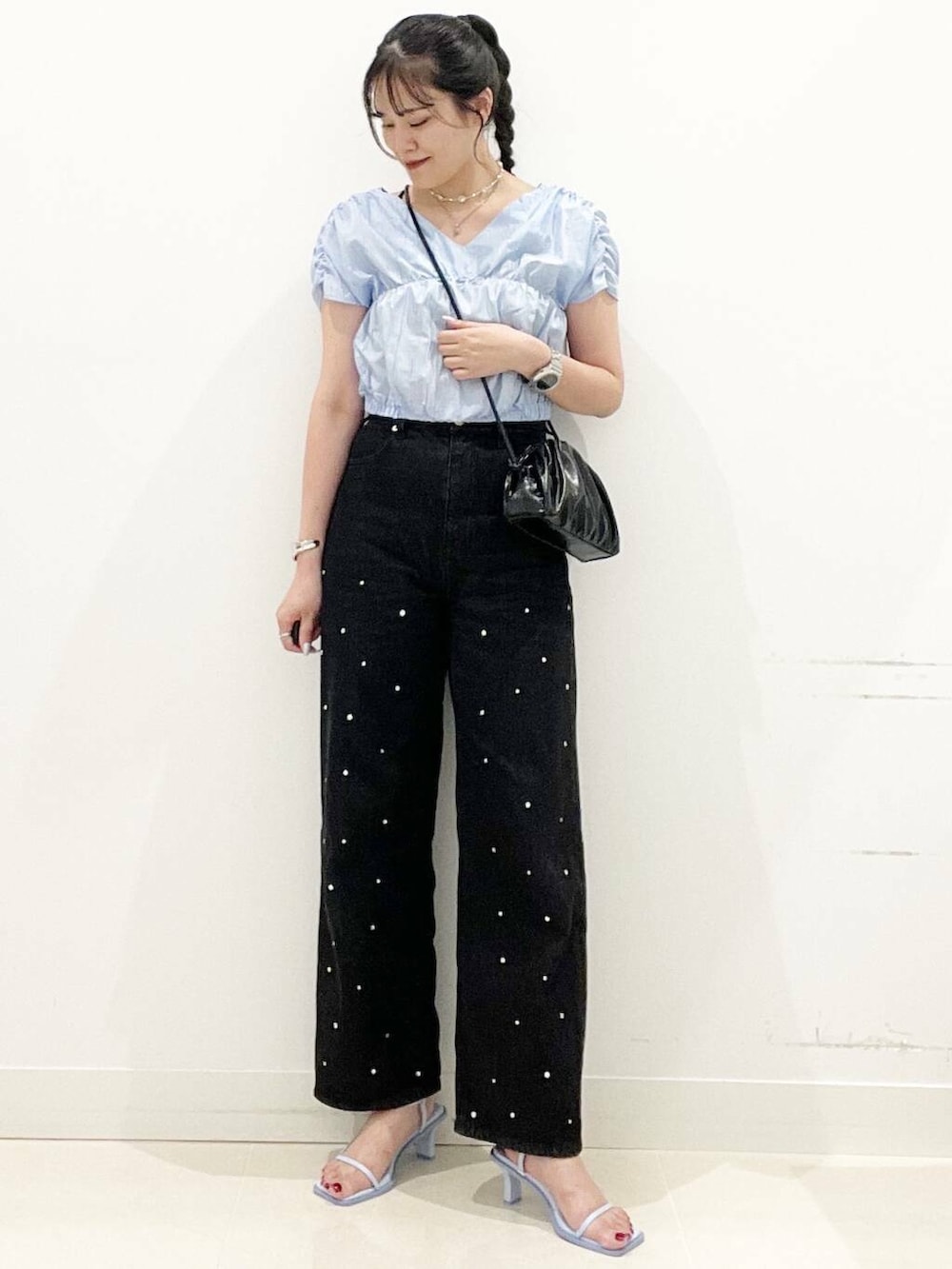 ブルー系のサンダル、ブラック系のショルダーバッグ、ブラック系のデニムパンツを着用したレディースの夏コーディネートの3枚目の写真