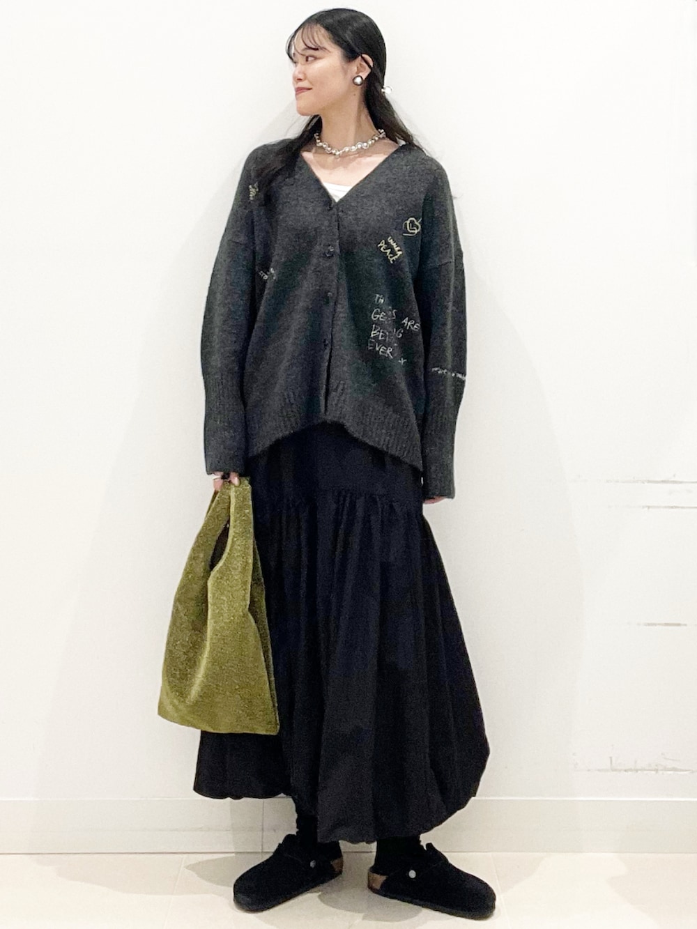 ホワイト系のTシャツ/カットソー、ゴールド系のトートバッグ、ブラック系のスカートを着用したレディースの秋コーディネートの3枚目の写真