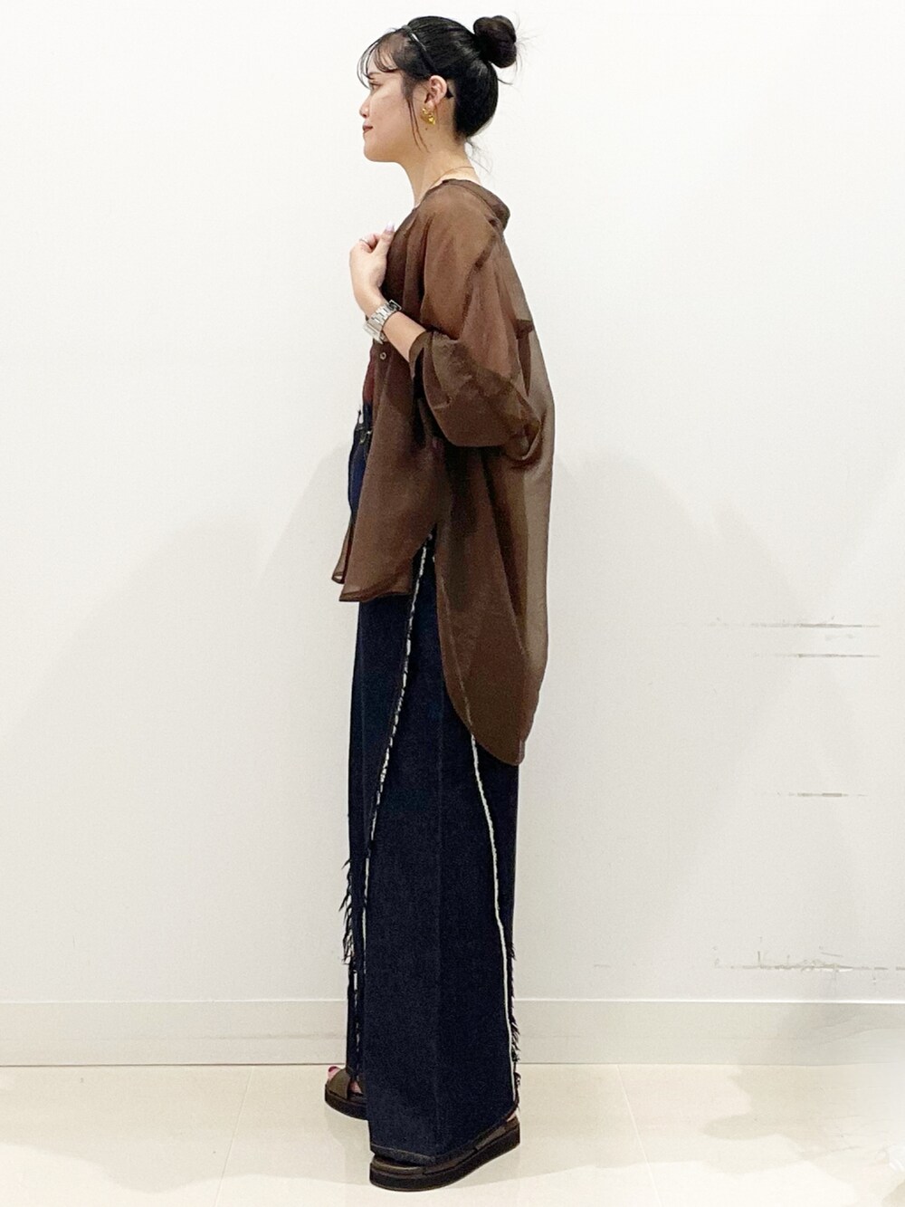 ブラウン系のサンダル、ブルー系のデニムパンツ、ブラック系のショルダーバッグを着用したレディースの夏コーディネートの4枚目の写真