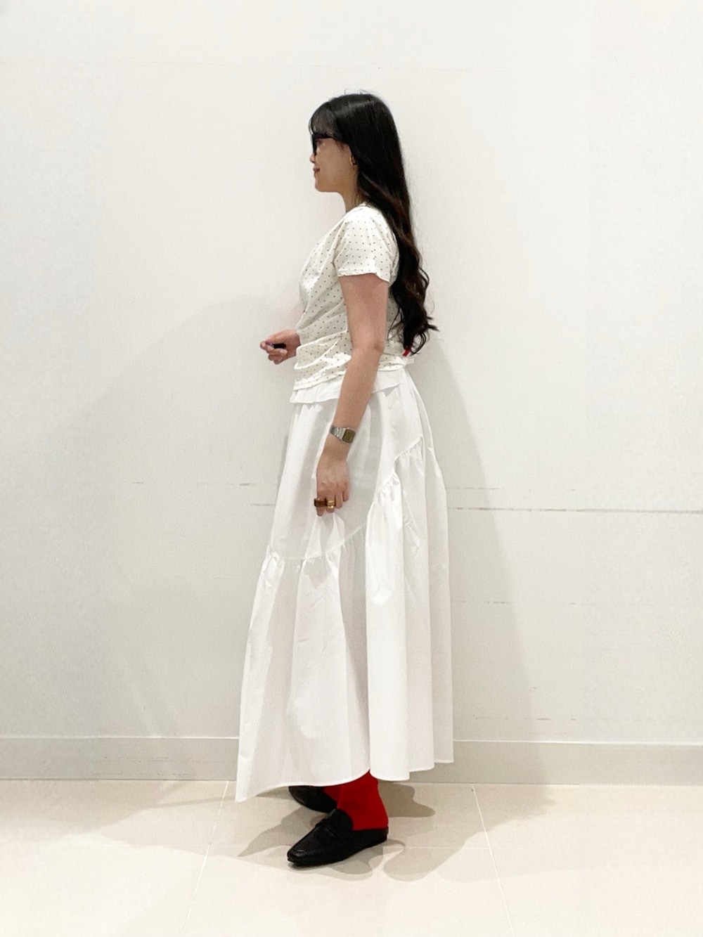 ホワイト系のスカート、ホワイト系のTシャツ/カットソー、レッド系のハンドバッグを着用したレディースの春コーディネートの6枚目の写真