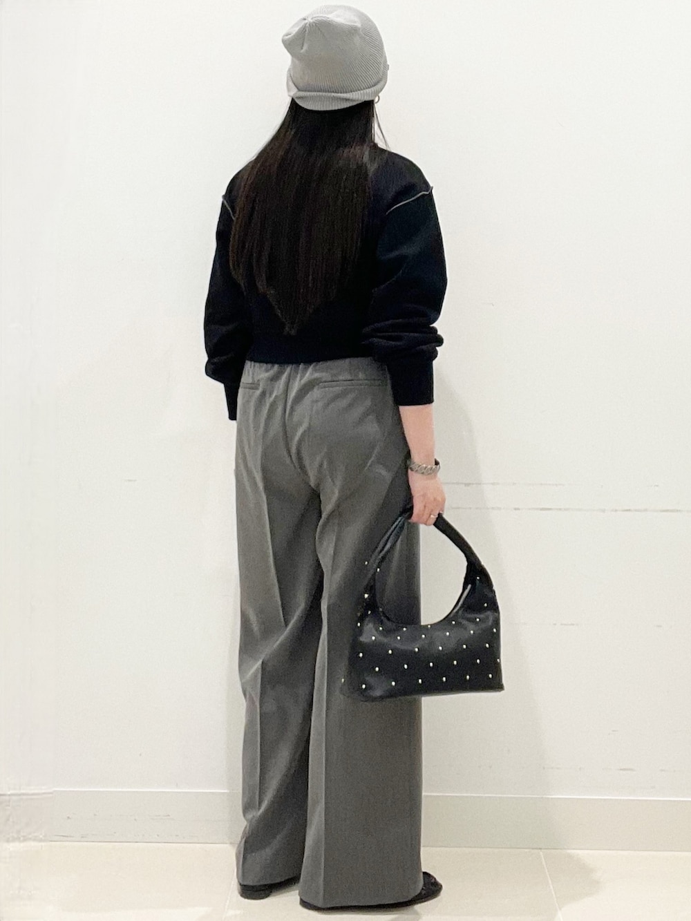 グレー系のスラックス、ブラック系のハンドバッグ、ブラック系のスウェットを着用したレディースの春コーディネートの6枚目の写真