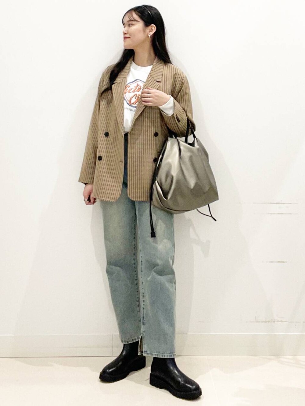 シルバー系のトートバッグ、ブルー系のその他パンツ、ブラック系のブーツを着用したレディースの秋コーディネートの3枚目の写真