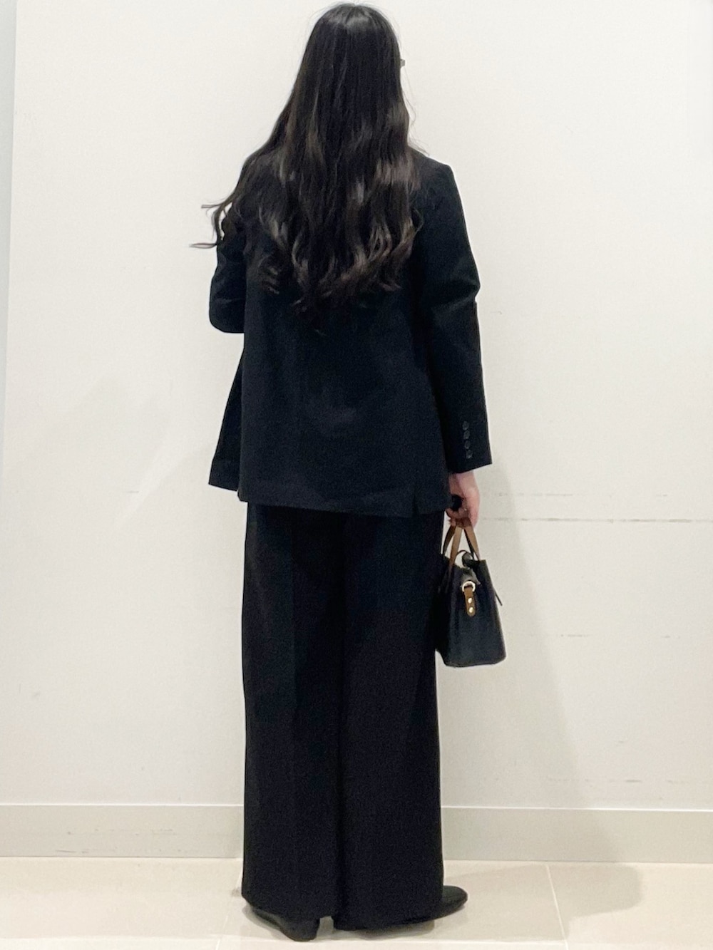 ブラック系のローファー、ブラック系のハンドバッグ、ブラック系のテーラードジャケットを着用したレディースの春コーディネートの5枚目の写真
