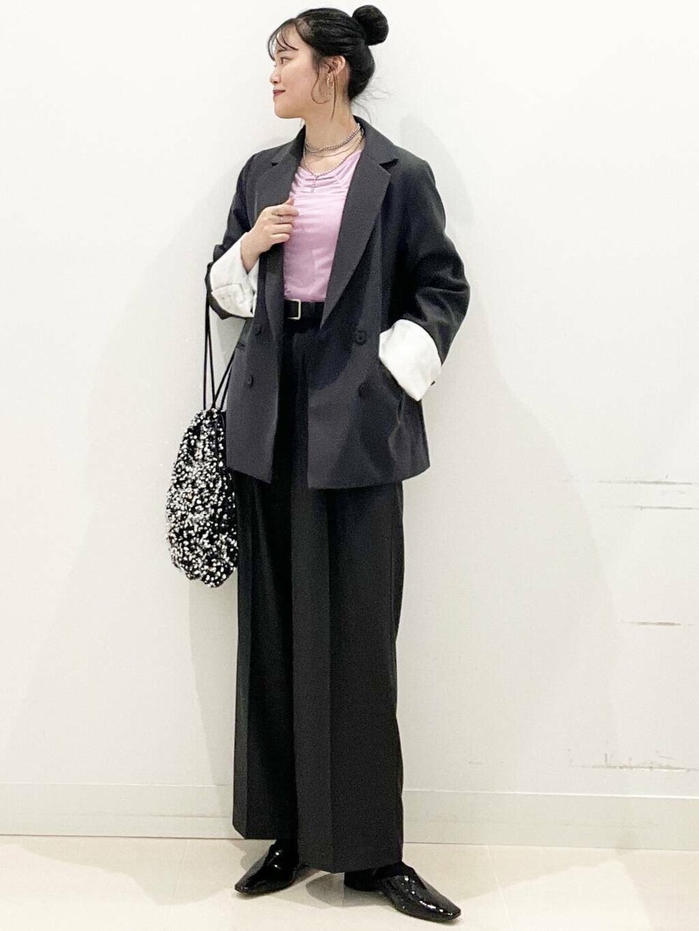 シルバー系のトートバッグ、グレー系のテーラードジャケット、グレー系のその他パンツを着用したレディースの冬コーディネートの3枚目の写真