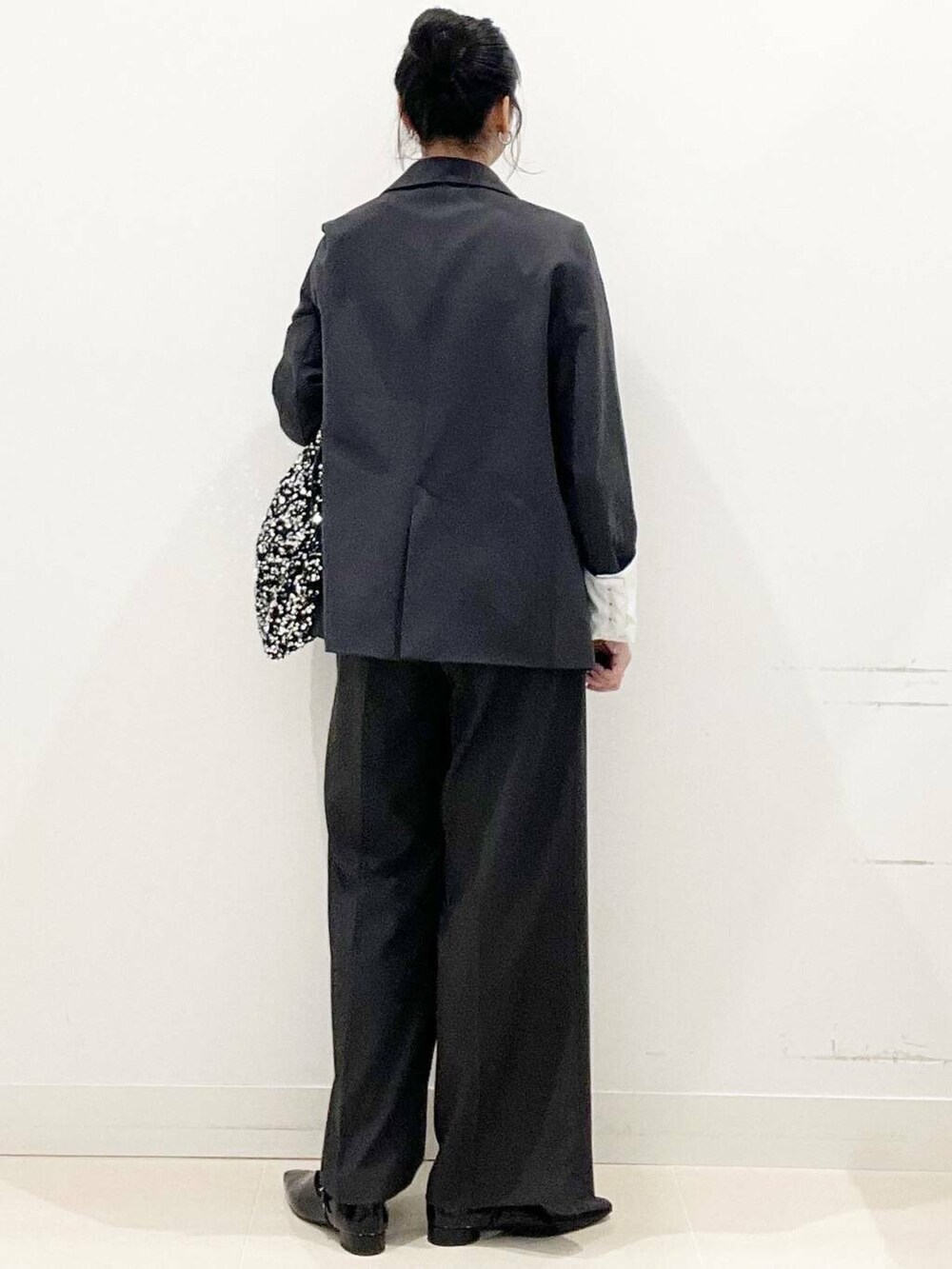 シルバー系のトートバッグ、グレー系のテーラードジャケット、グレー系のその他パンツを着用したレディースの冬コーディネートの6枚目の写真