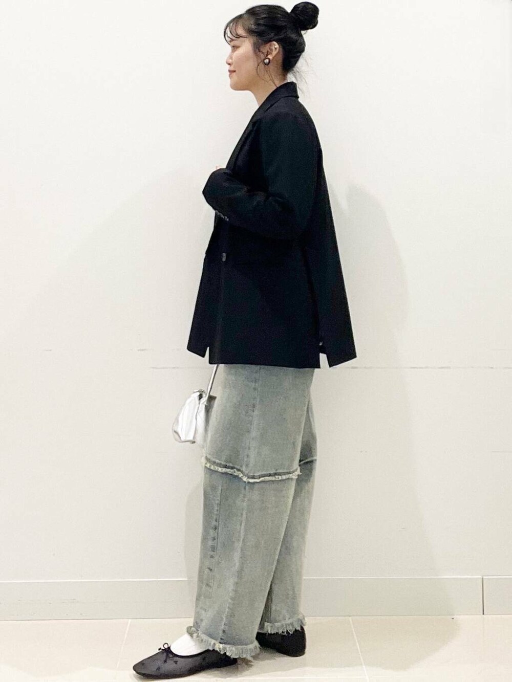 ブラック系のバレエシューズ、シルバー系のボストンバッグ、ブルー系のデニムパンツを着用したレディースの春コーディネートの5枚目の写真