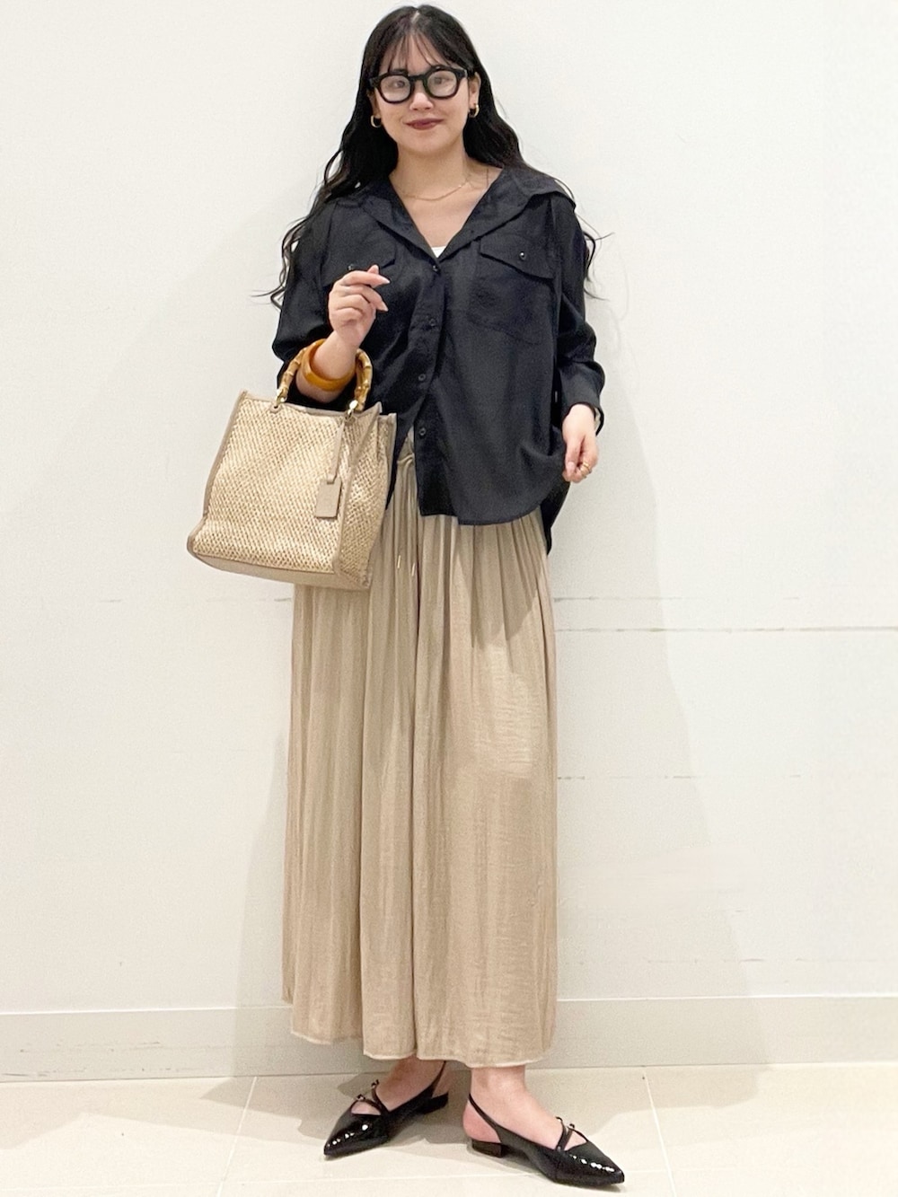 ベージュ系のその他パンツ、ホワイト系のキャミソール、ブラック系のパンプスを着用したレディースの春コーディネートの2枚目の写真